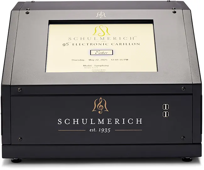 Schulmerich Symphony Carillon, a black digital carillon device with a sleek and modern design. It has a large touch display that shows the logo, current date, device model, version, and a prominent "Enter" button in the center.